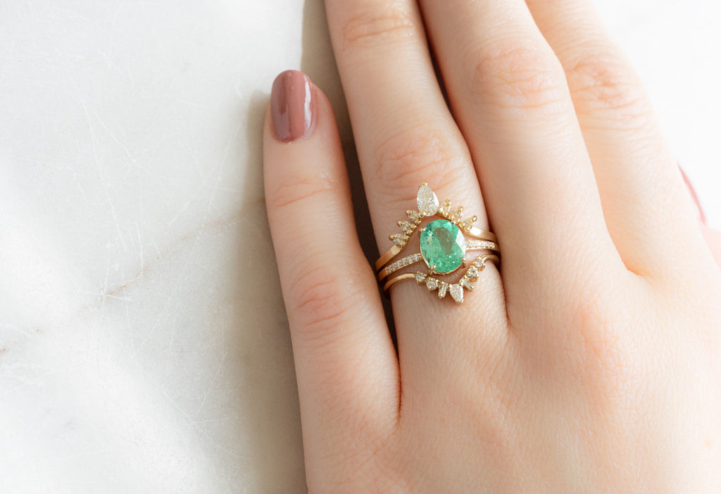 The Willow Ring with an Oval-Cut Emerald with White Diamond Stacking Bands on Model
