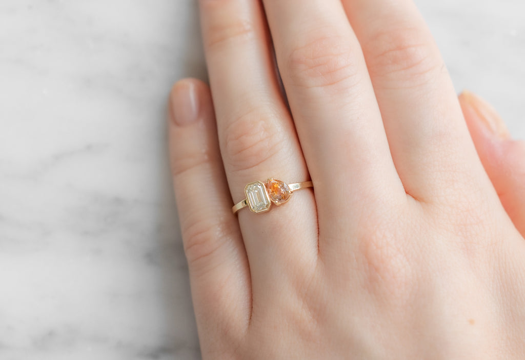 The You & Me Ring with an Emerald-Cut White Diamond + Bicolor Sapphire on Model