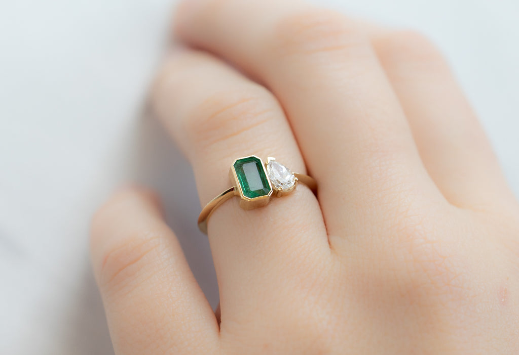 The You & Me Ring with an Emerald + White Diamond on Model