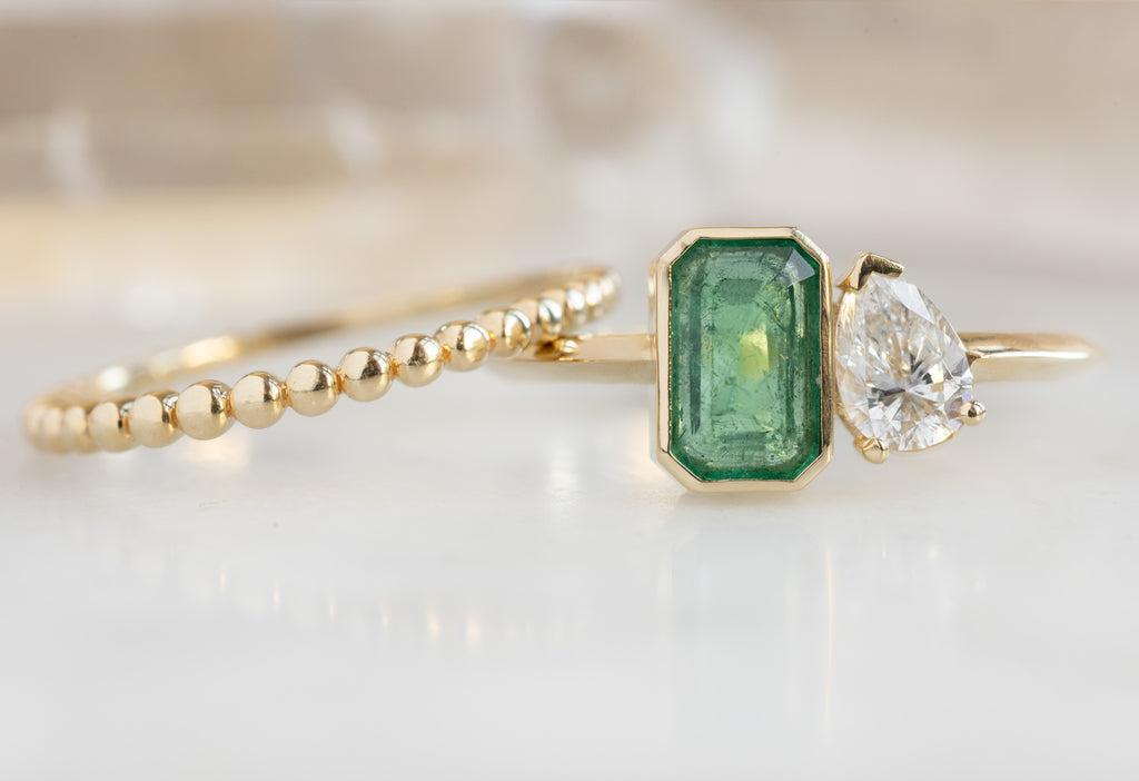 The You & Me Ring with an Emerald + White Diamond with Beaded Stacking Band