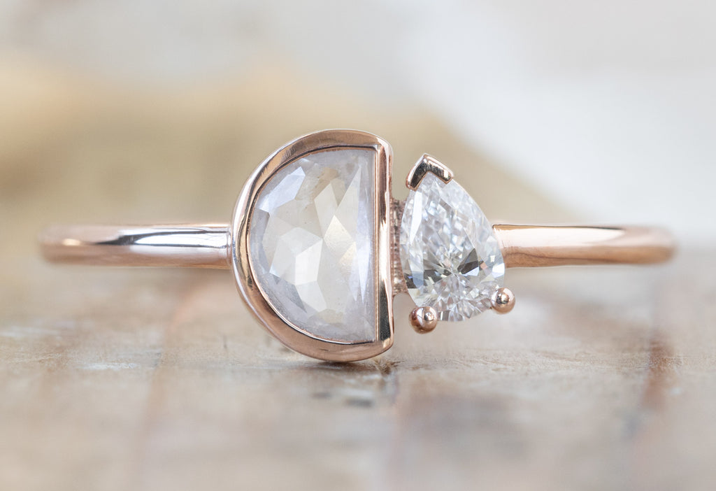 The You & Me Ring with an Opalescent Half-Moon + White Diamond on Wood Table