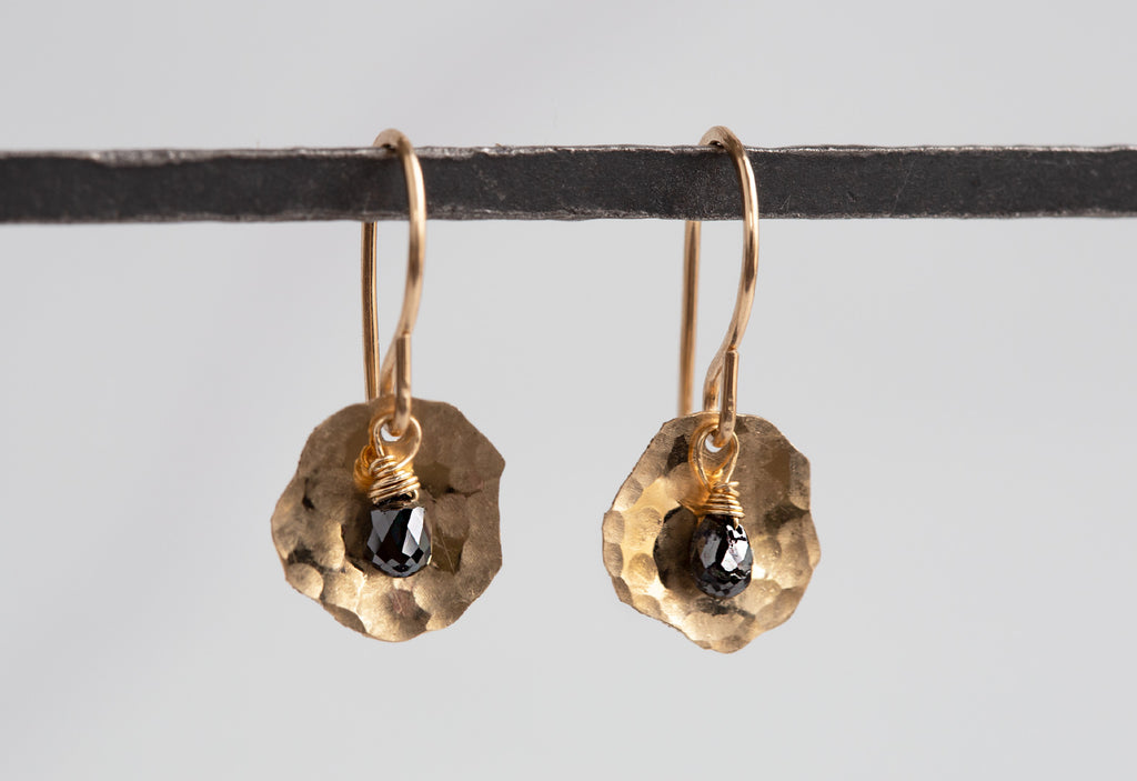 Black Diamond Petal Earrings hanging on metal rod