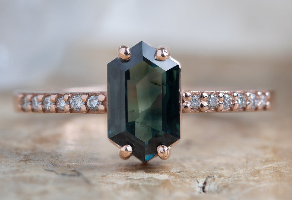 The Willow Ring with a Sapphire Hexagon Gemstone on Wood Table