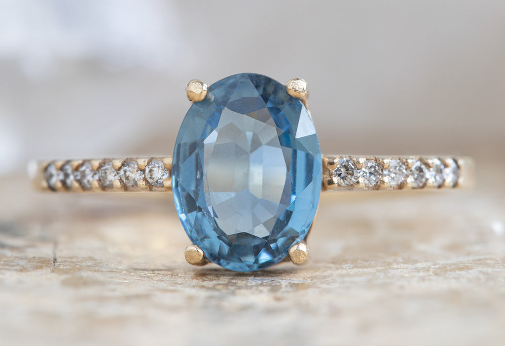 The Willow Ring with an Oval-Cut Sapphire on Wood Table