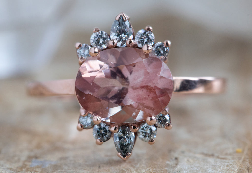 The Lotus Ring with an Oval-Cut Sunstone on Wood Table